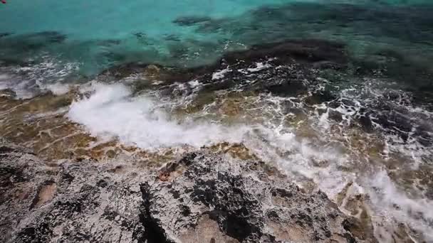 Il mare azzurro, un mare di colore berg, le onde si infrangono contro la riva rocciosa, sullo sfondo della linea costiera — Video Stock