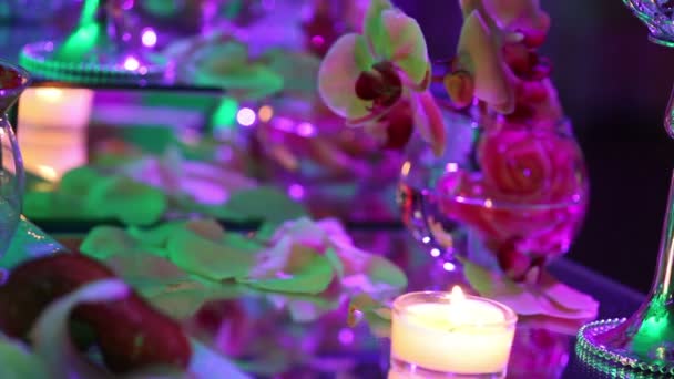 Декоративні свічки на обідньому столі, окуляри та різдвяні свічки на столі, білі воскові свічки зі скляною свічкою, свічки зі скляною свічкою, ресторан, інтер'єр, крупним планом — стокове відео