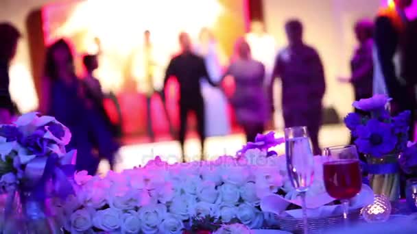 Groep silhouet mensen dansen in een donkere banketzaal voor een bruiloft receptie. The Wedding Banquet, mensen dansen - geschoten door de tabel huwelijksdecoratie, bruiloft decoratie — Stockvideo