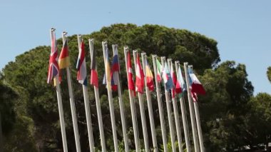 Renkli bayrak, mavi gökyüzü karşı sallanan birçok bayrakları rüzgarda sway.
