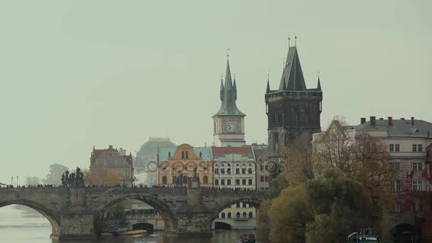 Uma torre velha do relógio perto da ponte em Praga, uma ponte através do rio na cidade velha — Vídeo de Stock
