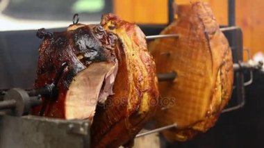 Lezzetli domuz jambon büyük boyutta bir açık ateş üzerinde pişmiş. Sokak gıda. Gıda açık havada. Kamp ve şiş ateşte pişirme, adam büyük parça et şiş yanıyor, closeup üzerinde aşçılar