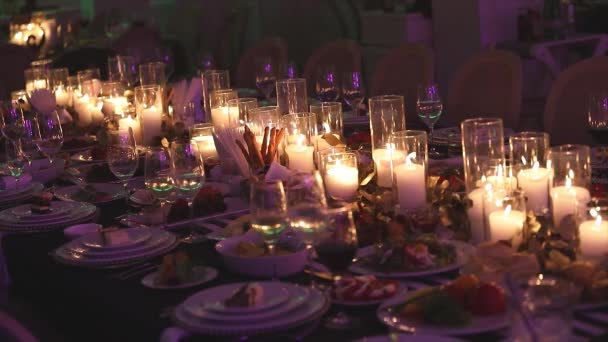Dekorkerzen auf dem Esstisch, Gläser und Weihnachtskerzen auf dem Tisch, weiße Wachskerzen mit Glaskerzenständer, Kerze mit Glaskerzenständer, Restaurant, Interieur, Nahaufnahme — Stockvideo