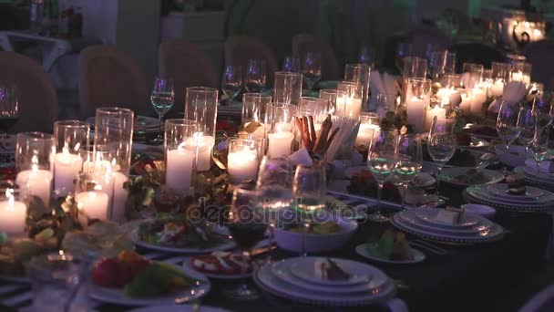 Velas decorativas en la mesa de comedor, vasos y velas de Navidad en la mesa, velas de cera blanca con candelero de vidrio — Vídeos de Stock