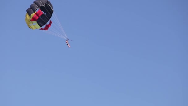 El barco enrolla a un hombre en un paracaídas, entretenimiento en el mar, hermosa costa, buen tiempo — Vídeo de stock
