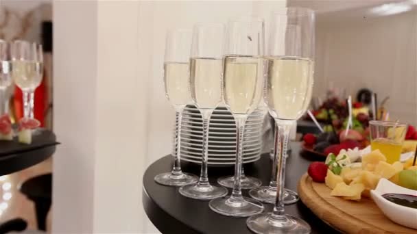 Glasses with champagne and fruits on buffet table, buffet table at a restaurant or in the hotel lobby, the camera along, shallow depth of field, welcoming guests in the lobby of the restaurant — Stock Video
