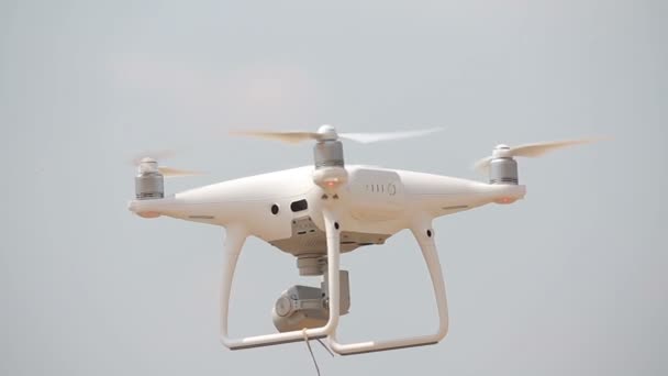 Des quadrupteurs blancs flottent dans les airs, des quadrocoptères volent, des hélices tournent, des quadrocoptères planent au-dessus du sol — Video