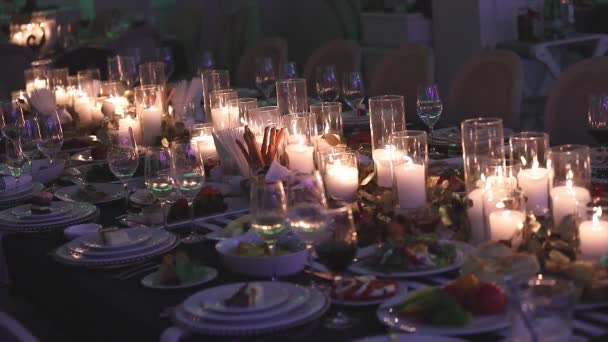Dekorativa ljus på matbordet, Glasögon och jul ljus på bordet, vitt vax candleswith glas ljusstake, ljus med glas ljusstake, restaurang, interiör, närbild — Stockvideo