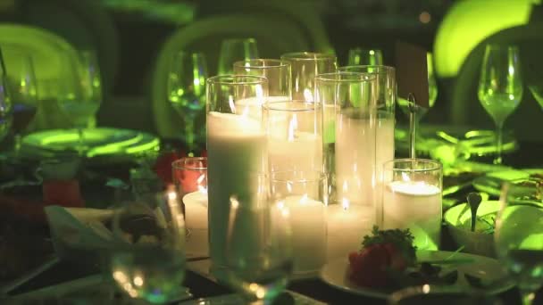 Velas decorativas na mesa de jantar, óculos e velas de Natal na mesa, velas de cera branca com castiçal de vidro, vela com castiçal de vidro, restaurante, interior, close-up — Vídeo de Stock