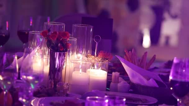 Декоративні свічки на обідньому столі, окуляри та різдвяні свічки на столі, білі воскові свічки зі скляною свічкою, свічки зі скляною свічкою, ресторан, інтер'єр, крупним планом — стокове відео