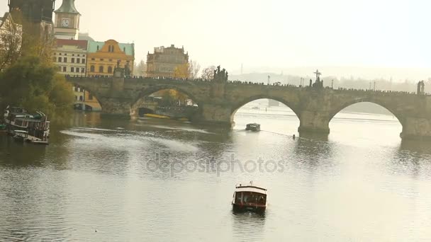 Barco turístico, en el fondo Puente de Carlos, Puente de Carlos, Praga con el telón de fondo de un barco turístico al atardecer — Vídeos de Stock