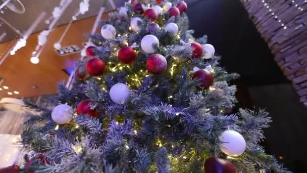 Grand sapin de Noël dans le hall de l'hôtel, restaurant. Arbre de Noël dans le hall sur le fond de l'escalier en marbre avec une main courante, vue du bas — Video