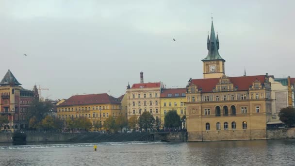 Uitzicht over de rivier naar de oude stad van Praag, excursie boot op de rivier, groothoek, The Charles Bridge, een toren met een klok, panorama, Praag — Stockvideo