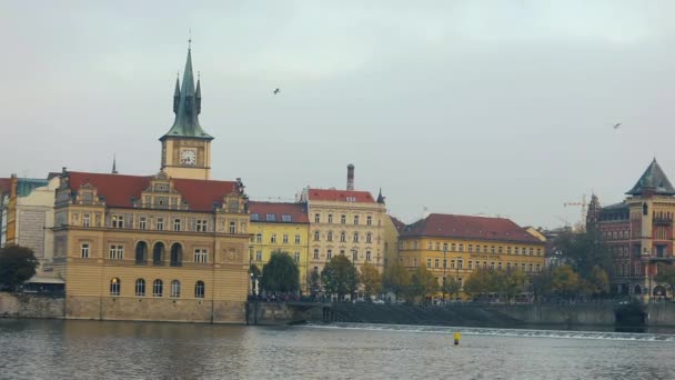 Vista do outro lado do rio para a cidade velha em Praga, barco de excursão no rio, ângulo largo, A Ponte Charles, uma torre com um relógio, panorama, Praga — Vídeo de Stock