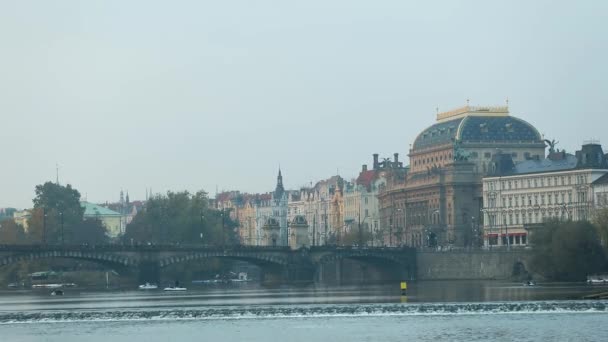 Vy över floden till gamla stan i Prag, utflyktsbåt vid floden, vidvinkel, The Charles Bridge, ett torn med en klocka, panorama, Prag — Stockvideo