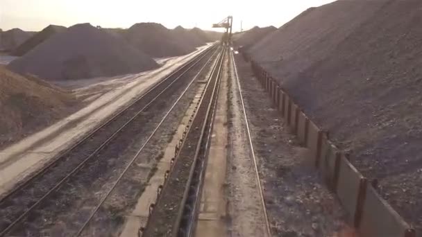 Vista aérea, maquinaria que trabaja en la cantera de arcilla, cargadoras pesadas, camiones grandes, topadoras, excavadoras, cantera de arena, minería, el tren toma materias primas de la cantera, almacén de arcilla grande — Vídeo de stock