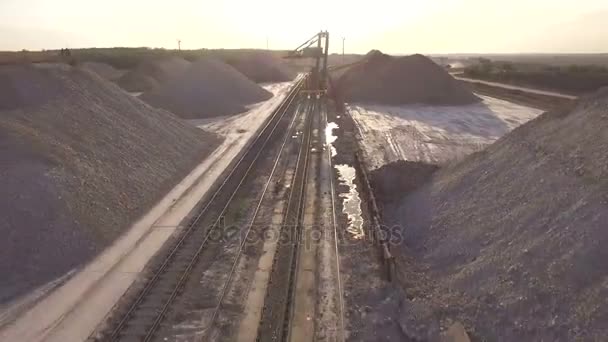 Vue aérienne, machinerie travaillant dans une carrière d'argile, chargeuses lourdes, gros camions, bulldozers, excavatrices, carrière de sable, exploitation minière, Le train prend les matières premières de la carrière, Grand entrepôt d'argile — Video