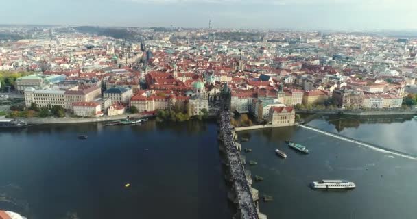 Vista panorámica desde arriba a la ciudad de Praga y el Puente de Carlos, turistas en el Puente de Carlos, Río Moldava, vuelo sobre el Puente de Carlos — Vídeos de Stock