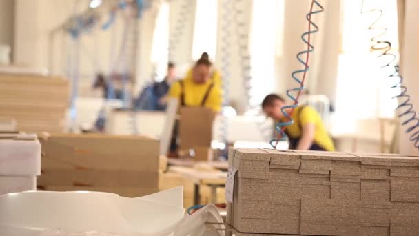 Работники мебельной фабрики в желтом комбинезоне собирают мебель, Производство мебели,, промышленный интерьер, небольшая глубина резкости — стоковое видео
