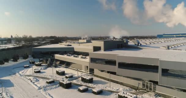 Bir modern fabrika veya ticari bir modern fabrika veya bina cephe ve otopark, bitki, hava, panoramik görünüm dış Kış saati, güneşli bir gün, mavi gökyüzü bina, — Stok video