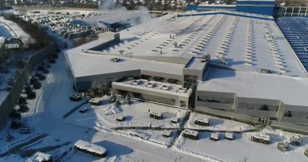 Een moderne fabriek of commerciële gebouw, de buitenkant van een moderne fabriek of fabriek, bouw van de gevel en de auto parkeren, panoramisch uitzicht vanuit de lucht, wintertijd, zonnige dag, blauwe hemel — Stockvideo