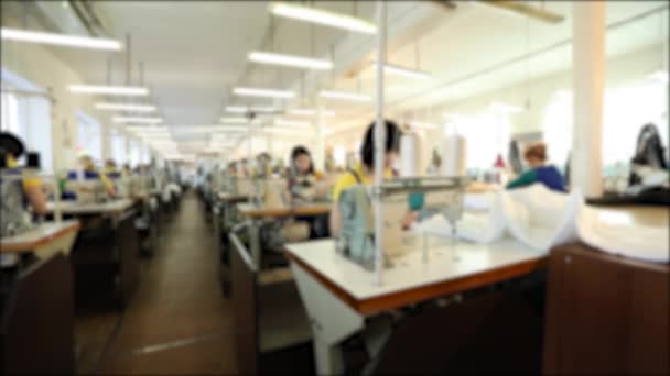 Industriegröße Textilfabrik, Arbeiter am Fließband, Nähproduktion, Frauen arbeiten für Nähmaschinen, Nähwerkstatt, Unschärfe, Unwiedererkennbarkeit — Stockvideo