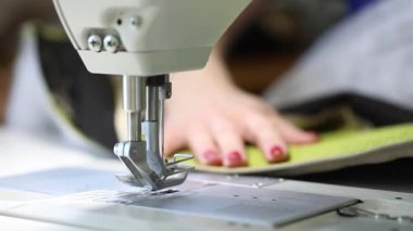Bir dikiş makinesi, iki iğneli dikiş makinesi, kırmızı manikür eller, ağır çekim Video, yakın çekim, endüstriyel dikiş makinesi üzerinde çalışan kadın