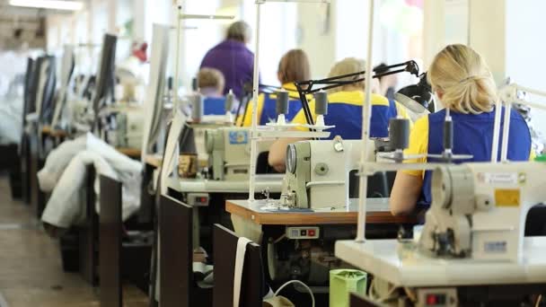 Жінка, що працює на швейній машині, текстильній фабриці промислового розміру, робітники на виробничій лінії, промисловому інтер'єрі, швейній машині для голки, мала глибина різкості — стокове відео