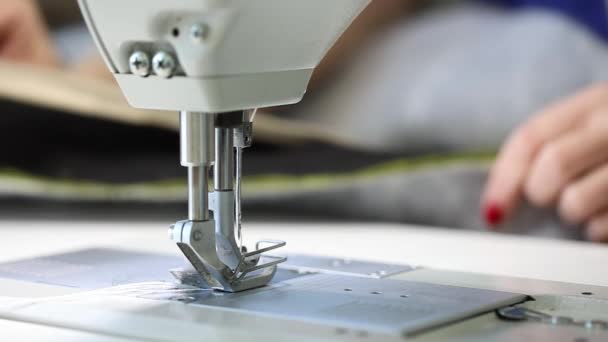 Женщина, работающая за швейной машинкой, двухигольная швейная машинка, красный маникюр на женских руках, Slow Motion Video, крупный план, промышленная швейная машинка — стоковое видео