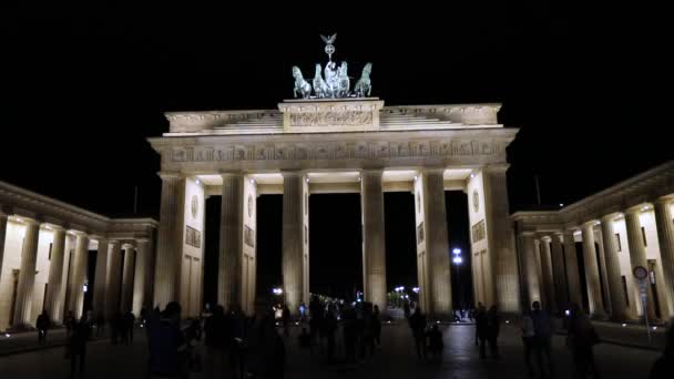 Vista nocturna de la Puerta de Brandenburgo en Berlín, la gente está caminando en la plaza, Alemania por la noche, Berlín — Vídeos de Stock