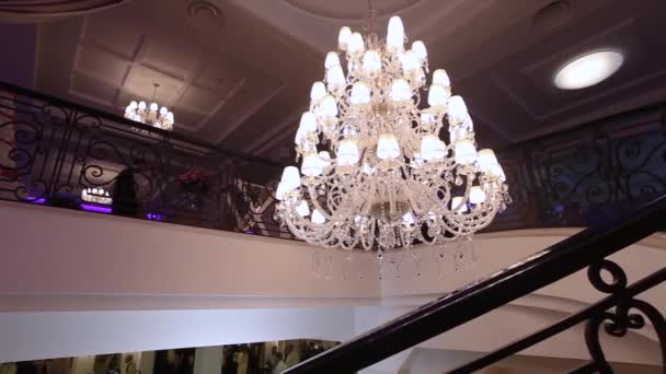 Lyxiga stora kristallkrona hängande i palatset. Vintage belysning lampor med lampor och en massa hängen. Den rika interiören i hallen i gamla åldrar. — Stockvideo