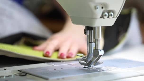 Mulher trabalhando em uma máquina de costura, máquina de costura de duas agulhas, manicure vermelho em mãos femininas, vídeo em câmera lenta, close-up, máquina de costura industrial — Vídeo de Stock