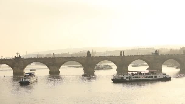 Туристы на Карловом мосту, Прага на фоне туристического корабля на закате, генеральный план — стоковое видео