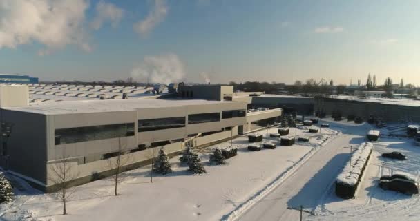 Moderní továrna nebo komerční budovy, exteriér moderní továrny nebo zařízení, fasáda a parkoviště, panoramatický pohled ze vzduchu, zimní čas, slunečný den, modrá obloha — Stock video