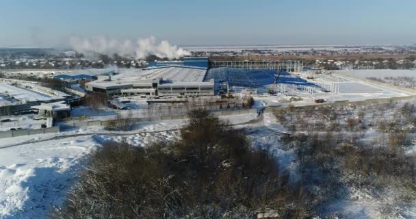 Moderní továrna nebo komerční budovy, exteriér moderní továrny nebo zařízení, fasáda a parkoviště, panoramatický pohled ze vzduchu, zimní čas, slunečný den, modrá obloha — Stock video