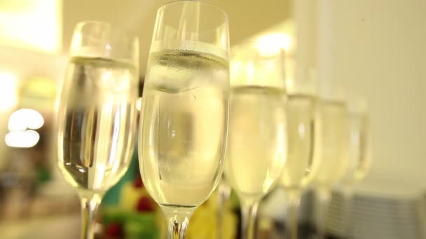 Close up di bicchieri di champagne con celebrazione del nuovo anno sullo sfondo . — Video Stock