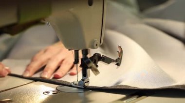 Çalışan bir dikiş makinesi, iğne dikiş makinesi, eller, ağır çekim Video, yakın çekim, sığ derinlik-in tarla, kadın endüstriyel dikiş makinesi