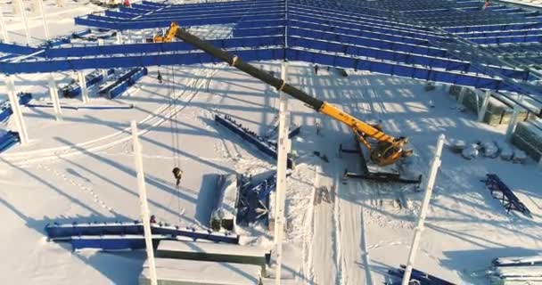 Costruzione di una moderna fabbrica o impianto, Zona industriale in inverno, vista panoramica dall'aria. Moderno impianto sul campo innevato, la struttura strutturale in acciaio di un nuovo edificio commerciale — Video Stock