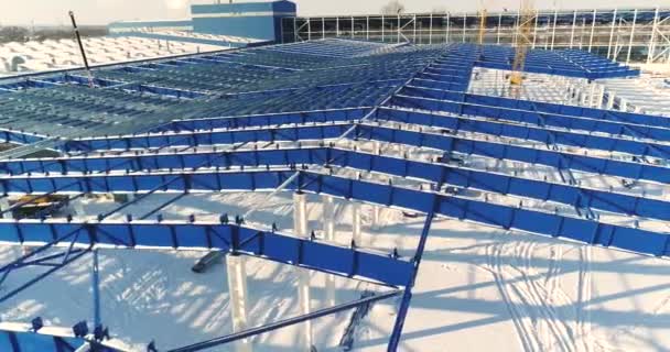 Construction d'une usine ou d'une usine moderne, Zone industrielle en hiver, vue panoramique de l'air. Usine moderne sur le terrain enneigé, la structure métallique structurelle d'un nouveau bâtiment commercial — Video