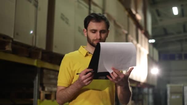 Le préposé à l'entrepôt fait un inventaire des marchandises. Le magasinier raconte les marchandises dans l'entrepôt et prend des notes. Gestionnaire de travail dans l'entrepôt — Video