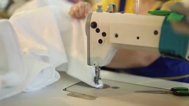 A woman works at a sewing factory, tailoring, dressmaking, sewing machine — Stock Video