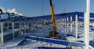 İnşaat sitede, Vinç vinç çalışmalarını demir kiriş yükseltir. İnşaat alanında yükseklikte emekçilerin inşaat sahasında işçiler. Tehlikeli bir iş.