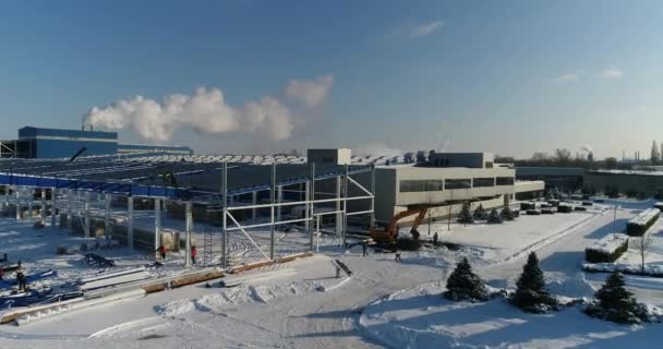 El trabajo de la grúa en el sitio de construcción, la grúa eleva la viga de hierro. Trabajadores en el sitio de construcción, personas que trabajan en la altura del sitio de construcción. Trabajo peligroso . — Vídeos de Stock