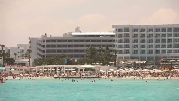 Sea resort, hotel junto al mar o al océano, gente en la playa junto al mar, costa, playa de arena, mar azul, entretenimiento en la playa — Vídeos de Stock