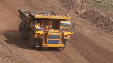 Yol boyunca bir damper sürmek, ocağı, endüstriyel dış sarı damperli kamyon