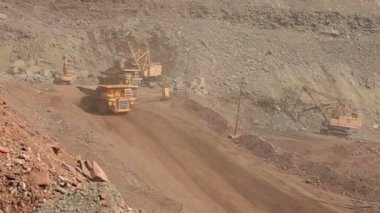 Yol boyunca bir damper sürmek, ocağı, endüstriyel dış sarı damperli kamyon