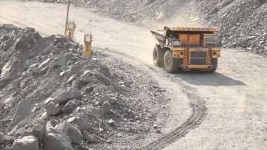 Yol boyunca bir damper sürmek, ocağı, endüstriyel dış sarı damperli kamyon