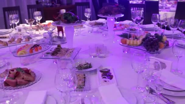 Fruta e comida na mesa do banquete no restaurante, pedaços de abacaxi e cachos de uvas na mesa do banquete, decoração do salão do banquete, interior do restaurante — Vídeo de Stock