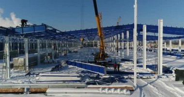 İnşaat sitede, Vinç vinç çalışmalarını demir kiriş yükseltir. İnşaat alanında yükseklikte emekçilerin inşaat sahasında işçiler. Tehlikeli bir iş.