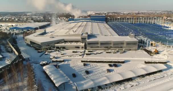 Una fábrica moderna o edificio comercial, el exterior de una fábrica o planta moderna, fachada del edificio y estacionamiento, vista panorámica desde el aire, tiempo de invierno, día soleado, cielo azul — Vídeo de stock